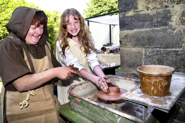 Lizzie Dykes goes potty with Sylvia Farnworth of Amos Hoskings potters to the kings of Cornwall at the Medieval Fair at St. Thomas the Martyr Church, Upholland, on Saturday 13th of July 2002.