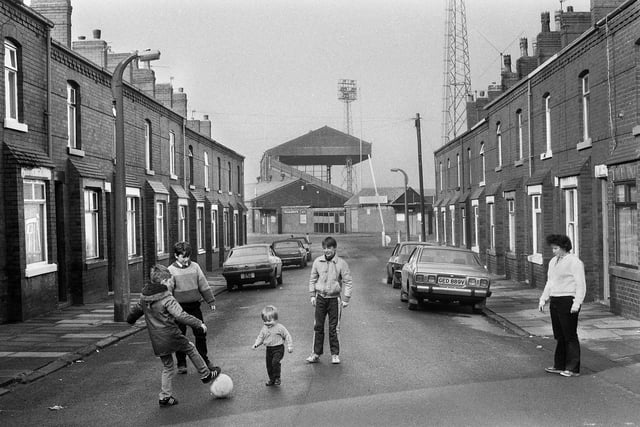 A game of street football in Second Avenue, Springfield, in the shadow of Wigan Athletic's Springfield Park ground in February 1985.