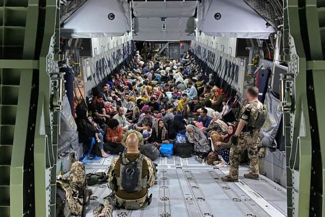 Evacuees from Kabul sit inside a military aircraft as they arrive at Tashkent Airport  in Tashkent, Uzbekistan