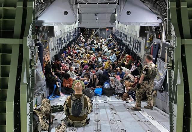 Evacuees from Kabul sit inside a military aircraft as they arrive at Tashkent Airport  in Tashkent, Uzbekistan