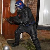 Police use a battering ram to break open a front door in Wigan during county lines raids