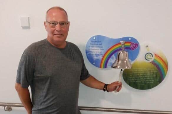 Stuart Keane rings a bell in hospital to mark the end of his cancer treatment