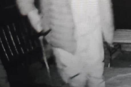 The man appears to be holding a sword or metal bar in his right hand