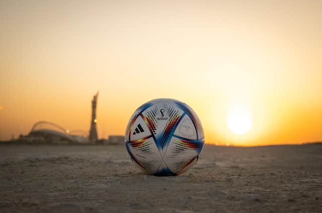 DOHA, QATAR - NOVEMBER 16: In this photo illustration, the Official Match Ball of FIFA World Cup Qatar 2022 is seen in front of Khalifa International Stadium at sunset ahead of the FIFA World Cup Qatar 2022 on November 16, 2022 in Doha, Qatar. (Photo by Ryan Pierse/Getty Images)
