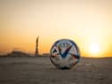 DOHA, QATAR - NOVEMBER 16: In this photo illustration,  the Official Match Ball of FIFA World Cup Qatar 2022 is seen in front of Khalifa International Stadium at sunset ahead of the FIFA World Cup Qatar 2022 on November 16, 2022 in Doha, Qatar. (Photo by Ryan Pierse/Getty Images)