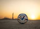 DOHA, QATAR - NOVEMBER 16: In this photo illustration,  the Official Match Ball of FIFA World Cup Qatar 2022 is seen in front of Khalifa International Stadium at sunset ahead of the FIFA World Cup Qatar 2022 on November 16, 2022 in Doha, Qatar. (Photo by Ryan Pierse/Getty Images)