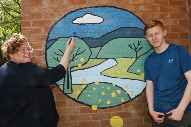from left, Teacher Rosella Cropper creating artwork on the walls with pupil Bobbie Lee, 15.