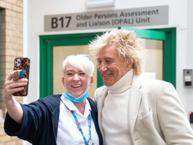 Sir Rod Stewart poses for photos with members of staff at the Princess Alexandra Hospital in Harlow, Essex