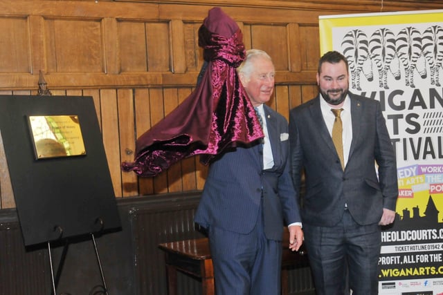 Prince Charles unveils a plaque, as he meets people from a variety of groups at The Old Courts, Wigan.