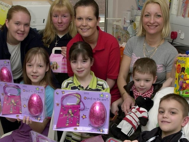 Emma Wood, left, and Jane Mather, from Marks and Spencer, Stadishgate, hand out Easter eggs to children on Wigan Infirmary's Rainbow Ward.  Rebecca Clark, 10, Emma McHugh, 10, and Nathan Bevan, eight, along with brother Ronan and mum Tina are pictured with play specialist Tracey Parfitt