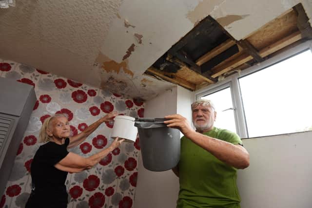 Gloria and Peter Armistead collect water getting inside their house through the roof