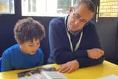 Volunteer supporting a child with their reading