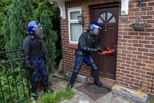 A battering ram is used to break down the front door of the house in Thorburn Road, Norley