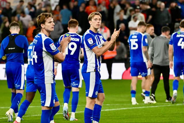 Wigan Athletic players applaud the travelling fans after their 1-0 defeat at Luton Town