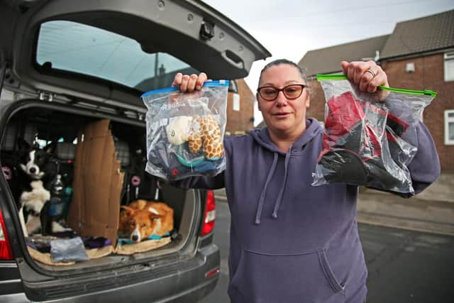 Jennie Alton holding up items belonging to lost dogs in which they seek to recover