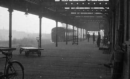 An atmospheric scene at Wigan Central on a grey and misty day in 1964.  Most of the Lancashire pits were still in operation and the clean air act of 1956 was still to take effect. A few souls are present as is the usual railway furniture such as the bicycle, platform trolley, sweeping brushes and bench. It was unusual for a town station to have a wooden decked platform and apart from any replacement planks, it remained as originally built until it was dismantled in 1972. (Author's Collection).