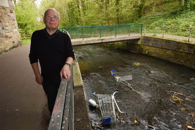 Coun George Davies with the trolleys thrown into the River Douglas