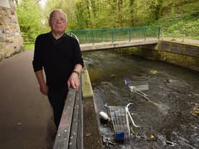 Coun George Davies with the trolleys thrown into the River Douglas