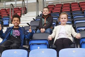 School pupils from left, Harvey Braun, Michael Lythgoe and  Darcey Hodge, during a sponsored seat sit, as they sat on 600 seats at the DW Stadium, Wigan, to raise funds for school sports equipment at RL Hughes primary school, Ashton-in-Makerfield.