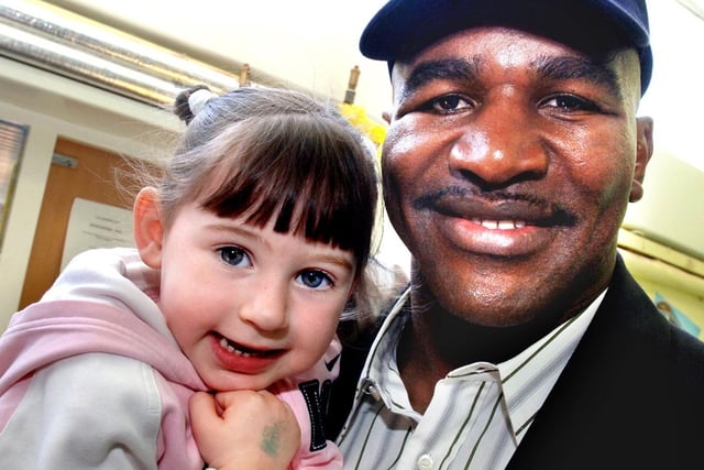 Famous boxer Evander Holyfield meets  Leah Halford, three, during his visit to Hope School.
