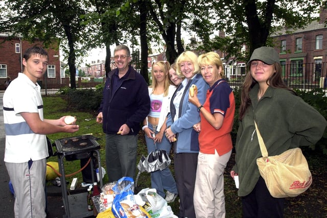 2002 Fun Day in Jubilee Park Ashton: The Burgermaster Peter Wilson hands out hamburgers from the barbeque run by Wigan Youth service.