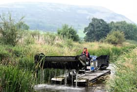 A weed removal boat in action