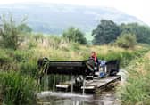A weed removal boat in action