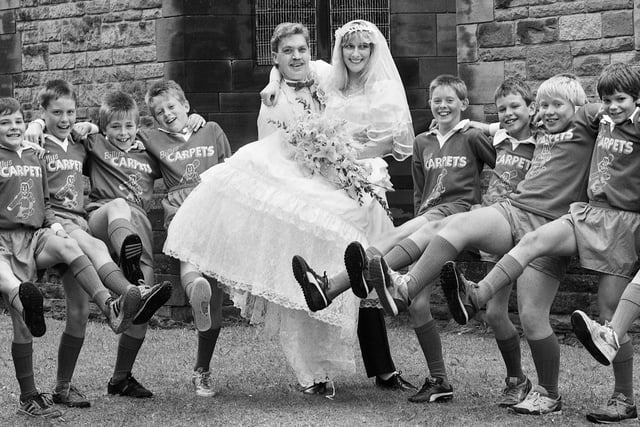Teaming up together for a match of the day are Eileen Bibby and William Sievewright with the Standish Juniors Under 12's football team.
The lads turned up for the wedding at St. Stephen's, Whelley, on Saturday 8th of August 1987 to form a guard of honour as a thank you to team sponsor William, of Billy's Carpets, Standish.