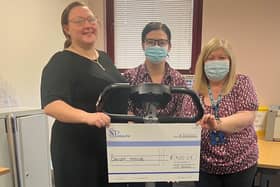 Staff at Poplar Street GP practice holding up a cheque with the funds they are donating to charity.