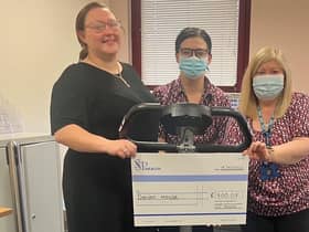 Staff at Poplar Street GP practice holding up a cheque with the funds they are donating to charity.