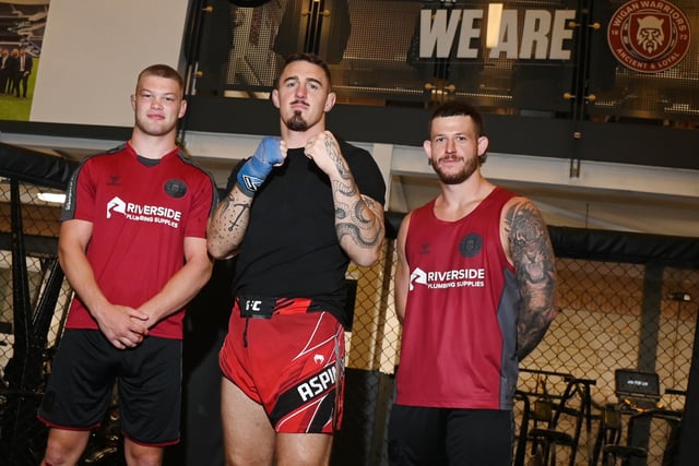 UFC Heavyweight Tom Aspinall, centre, with Wigan Warriors' Morgan Smithies, left, and Cade Cust, right.