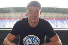 Charlie Hughes signs his new deal with Latics