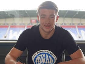 Charlie Hughes signs his new deal with Latics