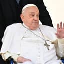 Pope Francis greets the crowd during a surprise appearance at the end of the mass for Palm Sunday at St Peter's Square in the Vatican on April 13