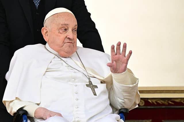 Pope Francis greets the crowd during a surprise appearance at the end of the mass for Palm Sunday at St Peter's Square in the Vatican on April 13