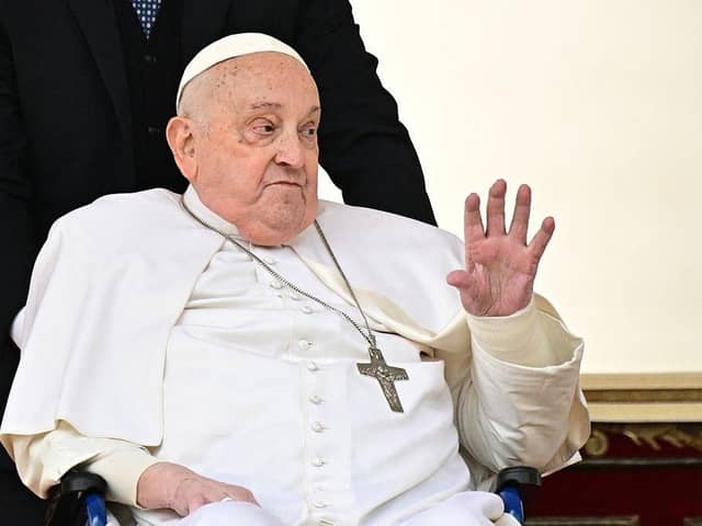 Pope Francis greets the crowd during a surprise appearance at the end of the mass for Palm Sunday at St Peter's Square in the Vatican on April 13