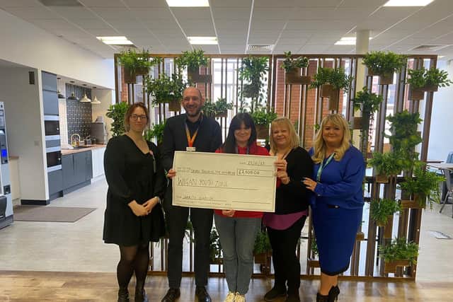 Staff from Interact Contact Centres presenting a cheque to Wigan Youth Zone's head of fundraising Lynsey Heyes