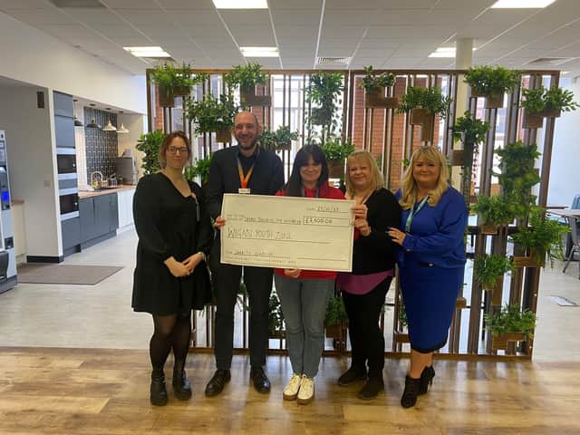 Staff from Interact Contact Centres presenting a cheque to Wigan Youth Zone's head of fundraising Lynsey Heyes