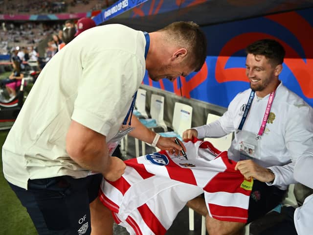 Owen Farrell signs a Wigan Warriors shirt before England's recent World Cup match against Japan in France