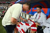 Owen Farrell signs a Wigan Warriors shirt before England's recent World Cup match against Japan in France