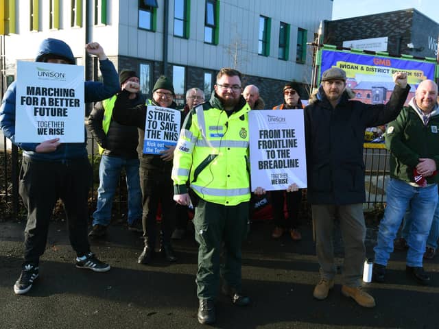 Paramedic Jonny White, centre, with colleagues and supporters at the picket line outside Wigan Community Fire and Ambulance Station