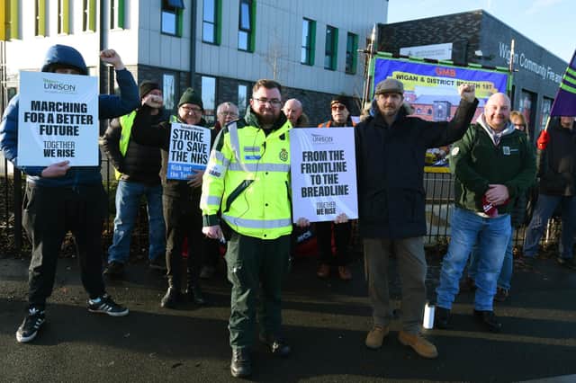 Paramedic Jonny White, centre, with colleagues and supporters at the picket line outside Wigan Community Fire and Ambulance Station