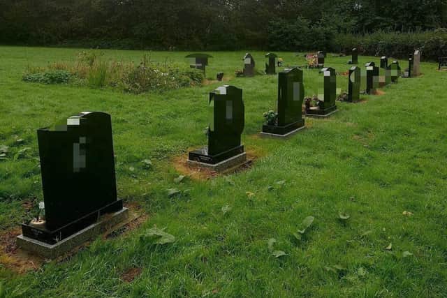 A pixelated photograph of the graves damaged with racist graffiti at Gidlow Cemetery