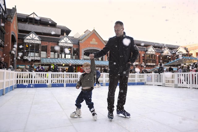 Luke Taylor, four, and his dad Malcolm, from Spring View, on a synthetic ice rink at Wigan Outdoor Market
