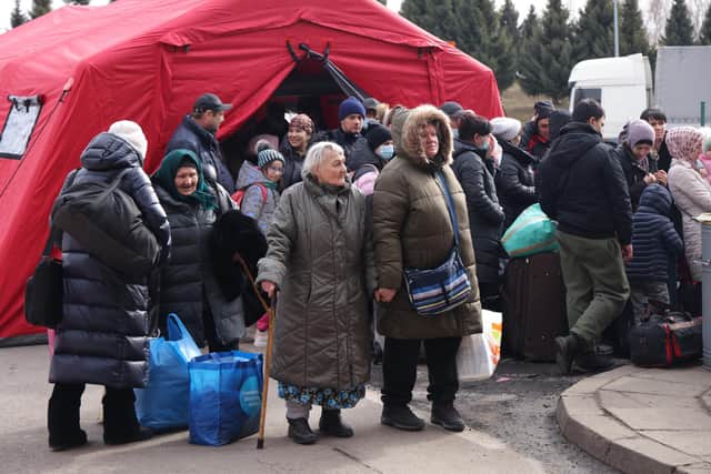 People fleeing war-torn Ukraine wait to cross into Poland at the Korczowa crossing. More than 400, 000 people have crossed the border into Poland from Ukraine in the first week since Russia's invasion.