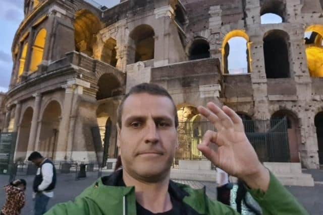 Chris Woodward does the Andy's Man Club hand gesture outside the Coliseum in Rome