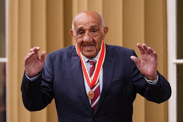 Sir Billy Boston poses with his medal after being knighted in an investiture ceremony at Buckingham Palace