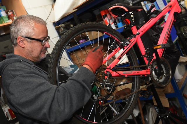 Volunteer Andy Saile works on a bicycle
