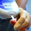 A nurse tests a patient with diabetes