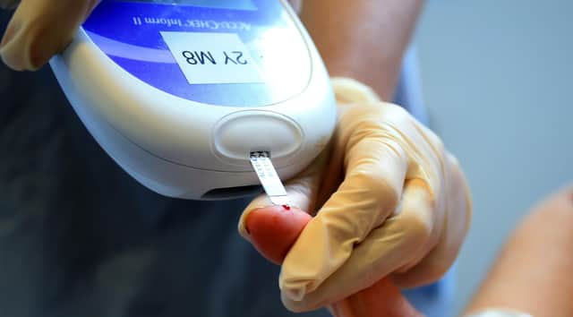 A nurse tests a patient with diabetes